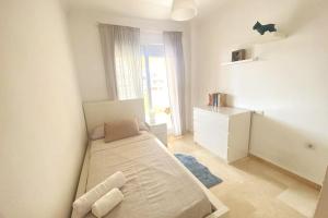 ein kleines weißes Schlafzimmer mit einem Bett und einer Kommode in der Unterkunft Fabuloso apartamento en Benalmadena con piscina in Benalmádena