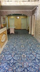 an empty room with a blue and white carpet at Guest House Dilorom in Khiva