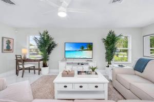 a living room with a couch and a tv at Luxury Designer Delray Beach. 10 Min to the Beach! in Delray Beach