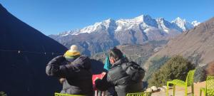 2 Personen stehen auf der Spitze eines Berges in der Unterkunft Trekker's Lodge in Thyāngboche