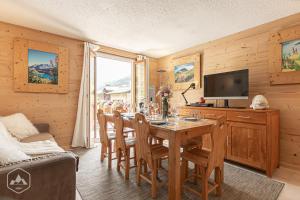 ein Esszimmer mit einem Tisch mit Stühlen und einem TV in der Unterkunft Locations Berne Milesi in Lanslevillard