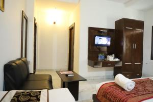 Habitación de hotel con 2 camas y TV en Hotel Tara Palace by Goyal Hoteliers en Agra