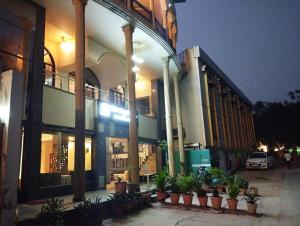 a large building with potted plants in front of it at Hotel Tara Palace by Goyal Hoteliers in Agra