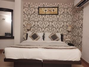 a bedroom with a large bed with a wall at Hotel Tara Palace by Goyal Hoteliers in Agra +41 photos