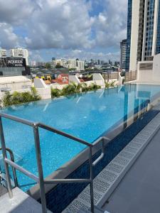 a large blue swimming pool on top of a building at Aqueen Prestige Hotel Jalan Besar in Singapore