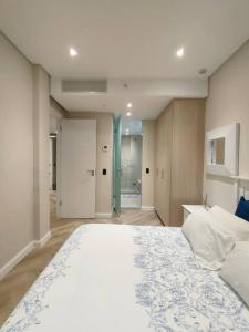 a bedroom with a large bed and a bathroom at Spacious 2BR APT Near Sandton City -No Loadshedding in Johannesburg