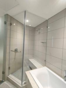a bathroom with a glass shower and a sink at Spacious 2BR APT Near Sandton City -No Loadshedding in Johannesburg