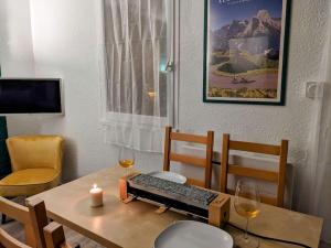 una mesa con teclado y dos copas de vino en Appartement 4 personnes et jardin, en Bielle