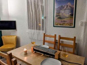a table with a keyboard and two glasses of wine at Appartement 4 personnes et jardin in Bielle