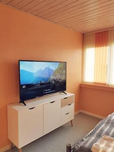 una sala de estar con TV de pantalla plana en un armario blanco en Comfortable 3- bedroom villa with free parking, en Roslev