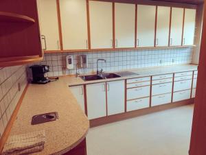 a kitchen with white cabinets and a counter top at Comfortable 3- bedroom villa with free parking in Roslev