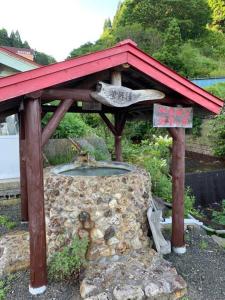 a stone fountain with a red roof on top at 854Annex in Kotaniishi