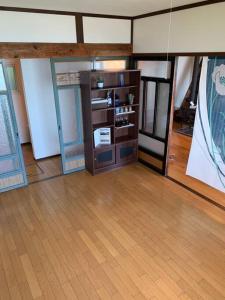 una habitación con suelo de madera y una habitación con un estante en 854Annex, en Kotaniishi
