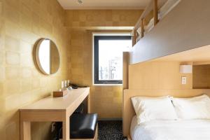 大阪的住宿－Meander Osaka，一间卧室配有一张床和一张带镜子的书桌