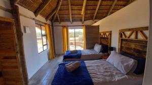a bedroom with two beds and a couch at FLY FISHING PARADISE ON THE VAAL in Parys
