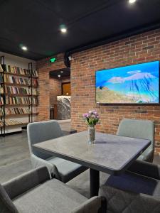 a room with a table and chairs and a tv at Orion Hostel in Yerevan