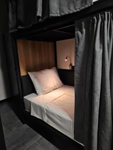 ein schwarzes Etagenbett mit weißer Bettwäsche und Kissen in der Unterkunft Orion Hostel in Yerevan