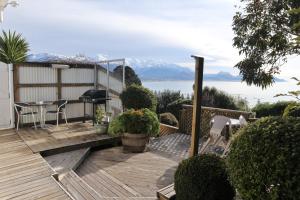 a deck with a table and chairs and a view of the water at Spectacular Views Convenient & Affordable in Kaikoura