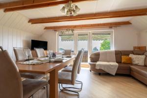 a dining room with a table and a couch at Vineyard Cottage Hočevar With Sauna - Happy Rentals in Novo Mesto