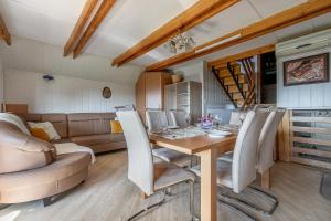 a dining room with a table and a couch at Vineyard Cottage Hočevar With Sauna - Happy Rentals in Novo Mesto