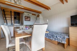a kitchen and dining room with a table and a bed at Vineyard Cottage Hočevar With Sauna - Happy Rentals in Novo Mesto +22 photos
