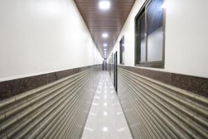 un largo pasillo con bancos vacíos en un edificio en Hotel Mumbai Residency, en Bombay
