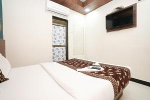 sypialnia z 2 łóżkami i telewizorem z płaskim ekranem w obiekcie Hotel Mumbai Residency w Bombaju