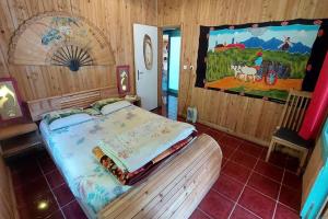 ein Schlafzimmer mit einem Bett und einem Wandgemälde in der Unterkunft Ma cabane à Cilaos in Cilaos