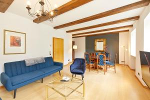 uma sala de estar com um sofá azul e uma sala de jantar em Haus am Hafen em Bernkastel-Kues
