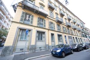 une voiture bleue garée devant un bâtiment dans l'établissement Porta Nuova Luxury Apartments, à Turin