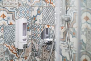a bathroom with a soap dispenser on a wall at Porta Nuova Luxury Apartments in Turin