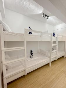 ボラカイにあるFully Furnished 2BR Newly Renovated Apartment by the White Beach - 1min walk from door stepの白い二段ベッドが備わる客室です。
