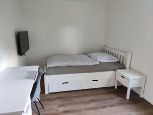 a bedroom with a bed and a desk and a chair at Apartmenthaus Pforzheim in Pforzheim