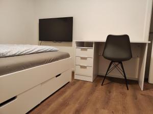a bedroom with a desk with a bed and a chair at Apartmenthaus Pforzheim in Pforzheim