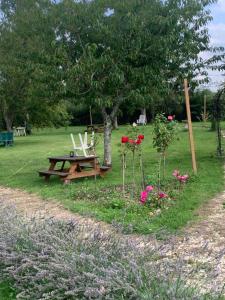 a picnic table and chairs in a field with flowers at Holistica - Bien être in Saint-Fargeau