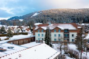 a town in the mountains with snow on the roofs at Azureva Métabief in Métabief