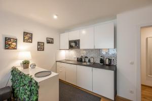 a kitchen with white cabinets and a table in a room at Modern City Center Apartment in Vienna