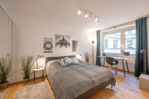 a bedroom with a bed and a desk and a window at Modern City Center Apartment in Vienna +13 photos