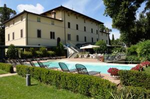 a building with a swimming pool in front of a building at Posta Donini 1579 - UNA Esperienze in San Martino in Campo