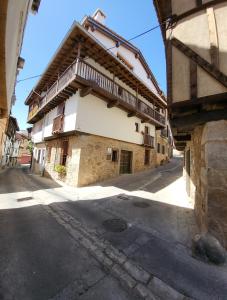 a building with a balcony on the side of a street at Casa Rural: La casa El cura in Madrigal de la Vera