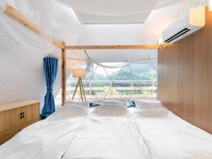 1 dormitorio con 1 cama grande y ventana en SPRINGS VILLAGE 足柄 丹沢温泉リゾート＆グランピング, en Hata