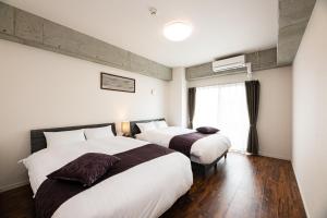 pokój hotelowy z 2 łóżkami i oknem w obiekcie STAYTUS - Vacation STAY 62201v w mieście Kagoshima