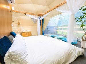 a bedroom with a bed in a tent at SPRINGS VILLAGE 足柄 丹沢温泉リゾート＆グランピング in Hata