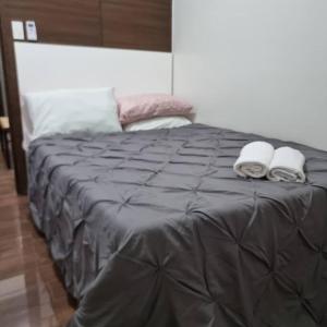 a bed with two towels and two pillows on it at UNIT 4765 AIR in Manila