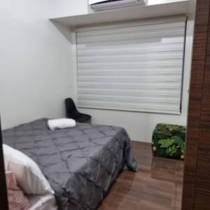 a bedroom with a bed and a window and a chair at UNIT 4765 AIR in Manila