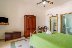 a bedroom with a green bed and a tv at Domus mea salento Arazzo Verde in Ugento