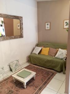 a living room with a couch and a mirror at Charme et sérénité pour NON FUMEURS uniquement ! in Saint-Pierre