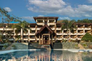 a building with a pool in front of a resort at Coron Westown Resort in Coron