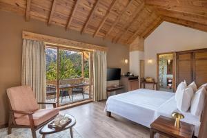 1 dormitorio con 1 cama grande y balcón en Welcomhotel By ITC Hotels, Hamsa Manali, en Manali