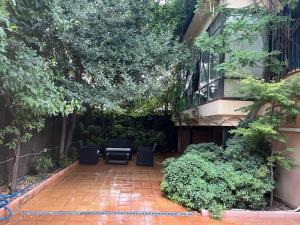 a courtyard with chairs and trees and a building at The Garden Madrid in Madrid